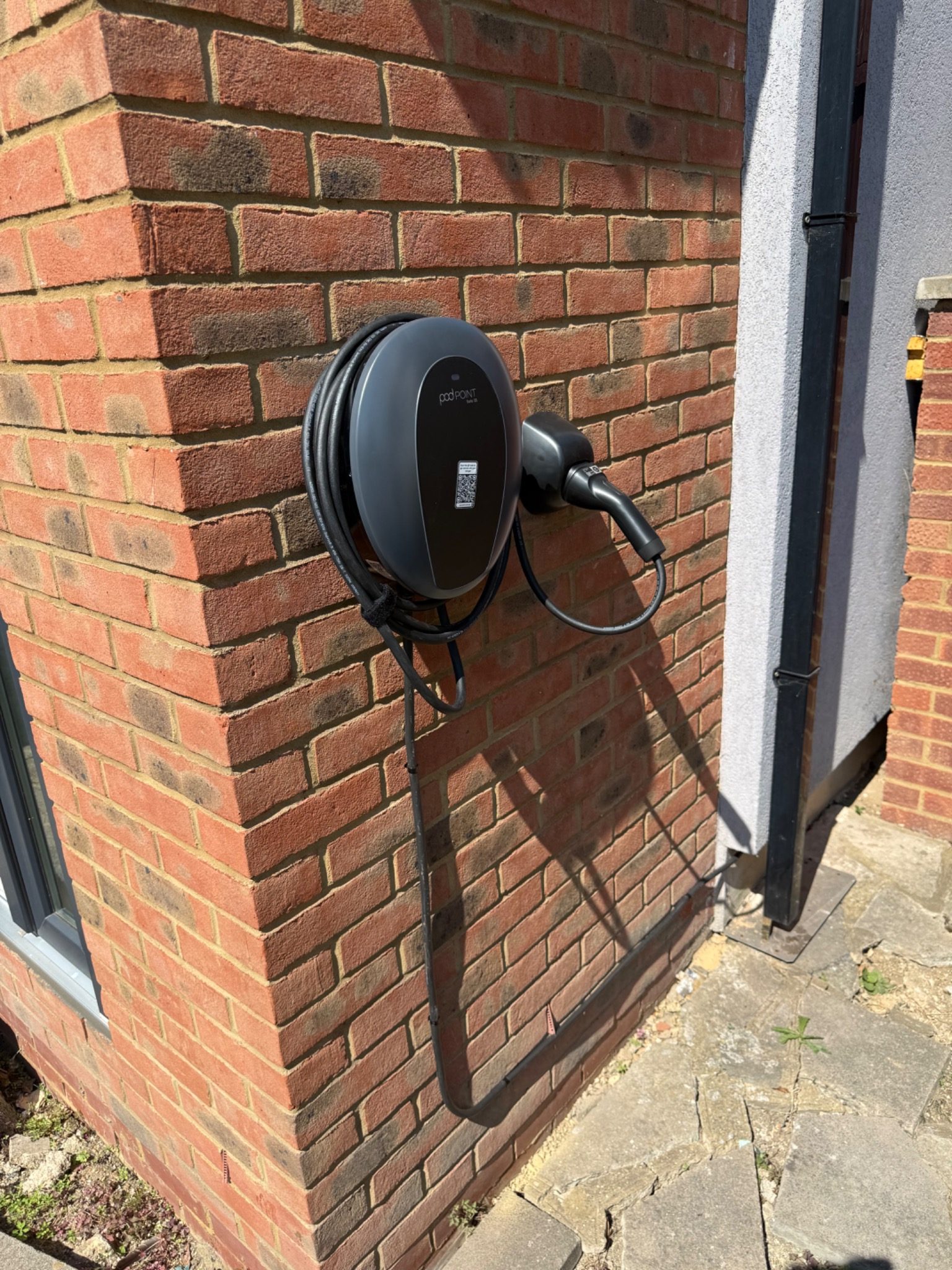 Pod Point Solo 3S EV charger installed on an external brick wall at a home in Hillingdon